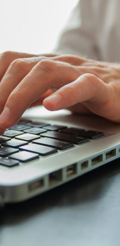Main d'une personne tapant sur un clavier d'ordinateur portable.