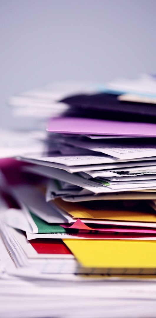 Tas de papiers colorés en désordre, incluant des feuilles et des documents variés.
